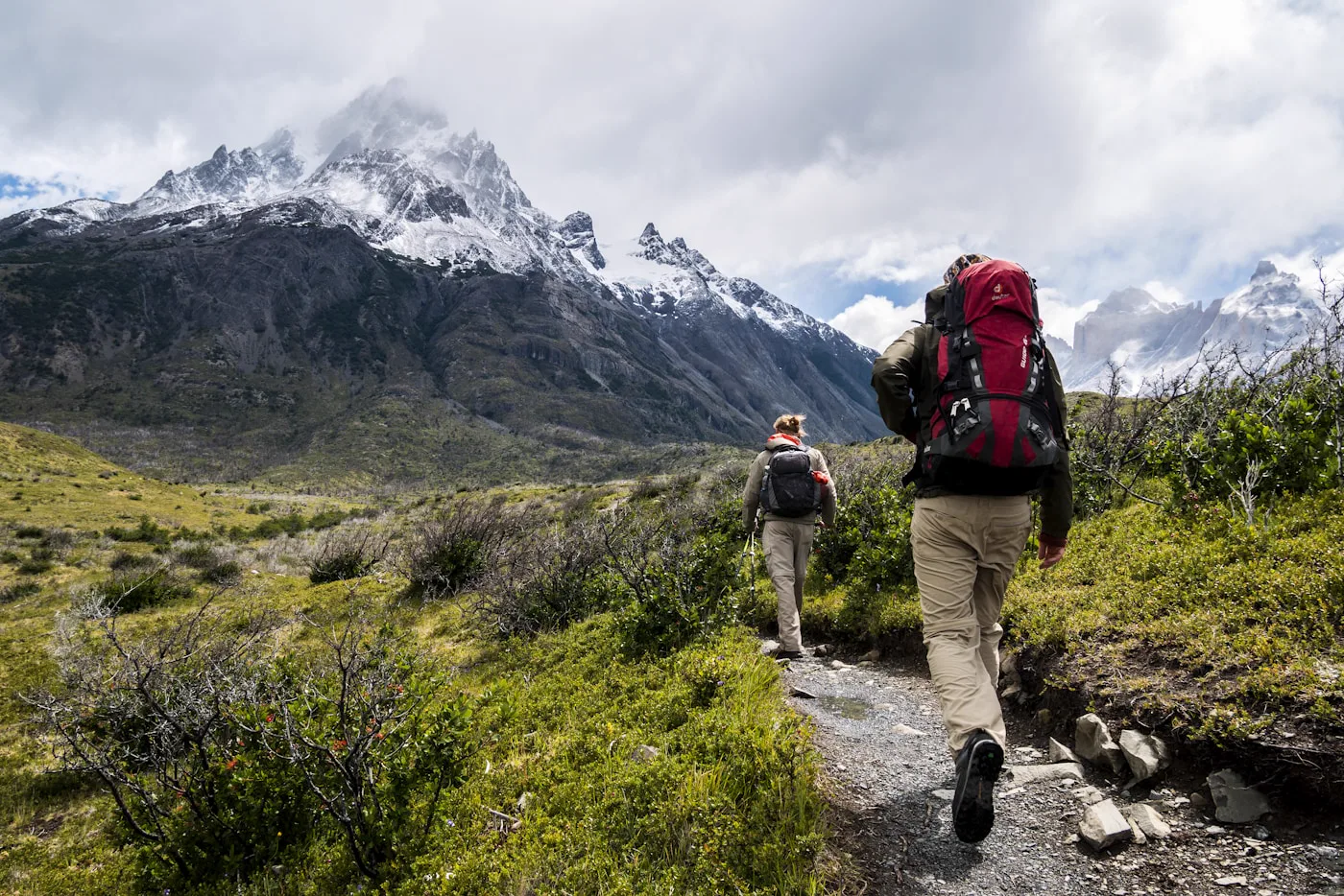 Grupo pequeño caminando por camino de montaña con mochila ligera